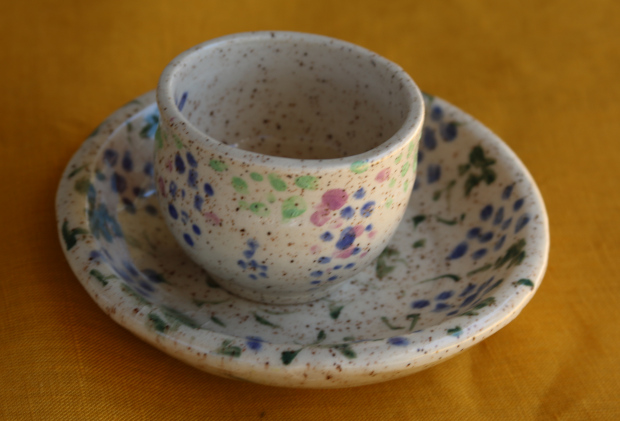 Cup on saucer with illustrations of grapes, speckled clay with underglazes