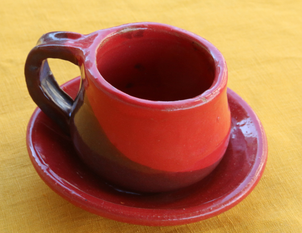 Red and maroon cup on red saucer 